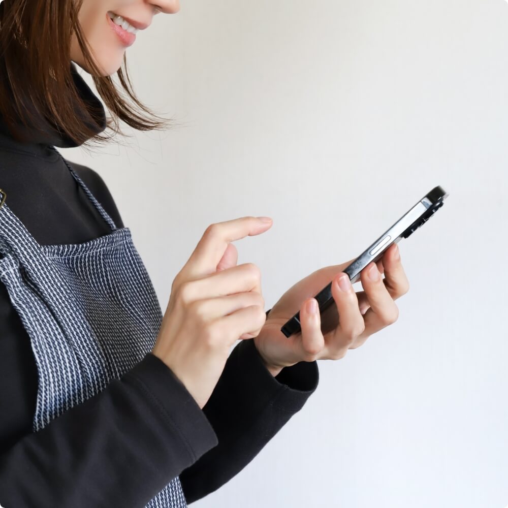 スマートフォンで予約する女性